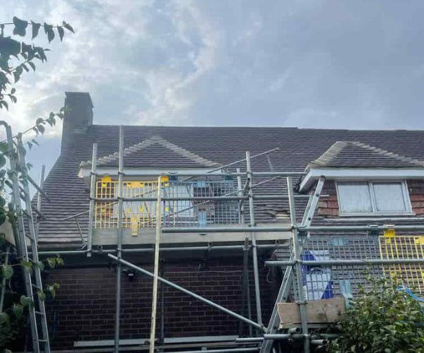 This is a photo of a roof with two dormers that is having some damaged tiles replaced. Works carried out by PER Roofing Godmanchester